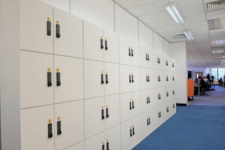 Cream lockers with black digital locks on an office environment