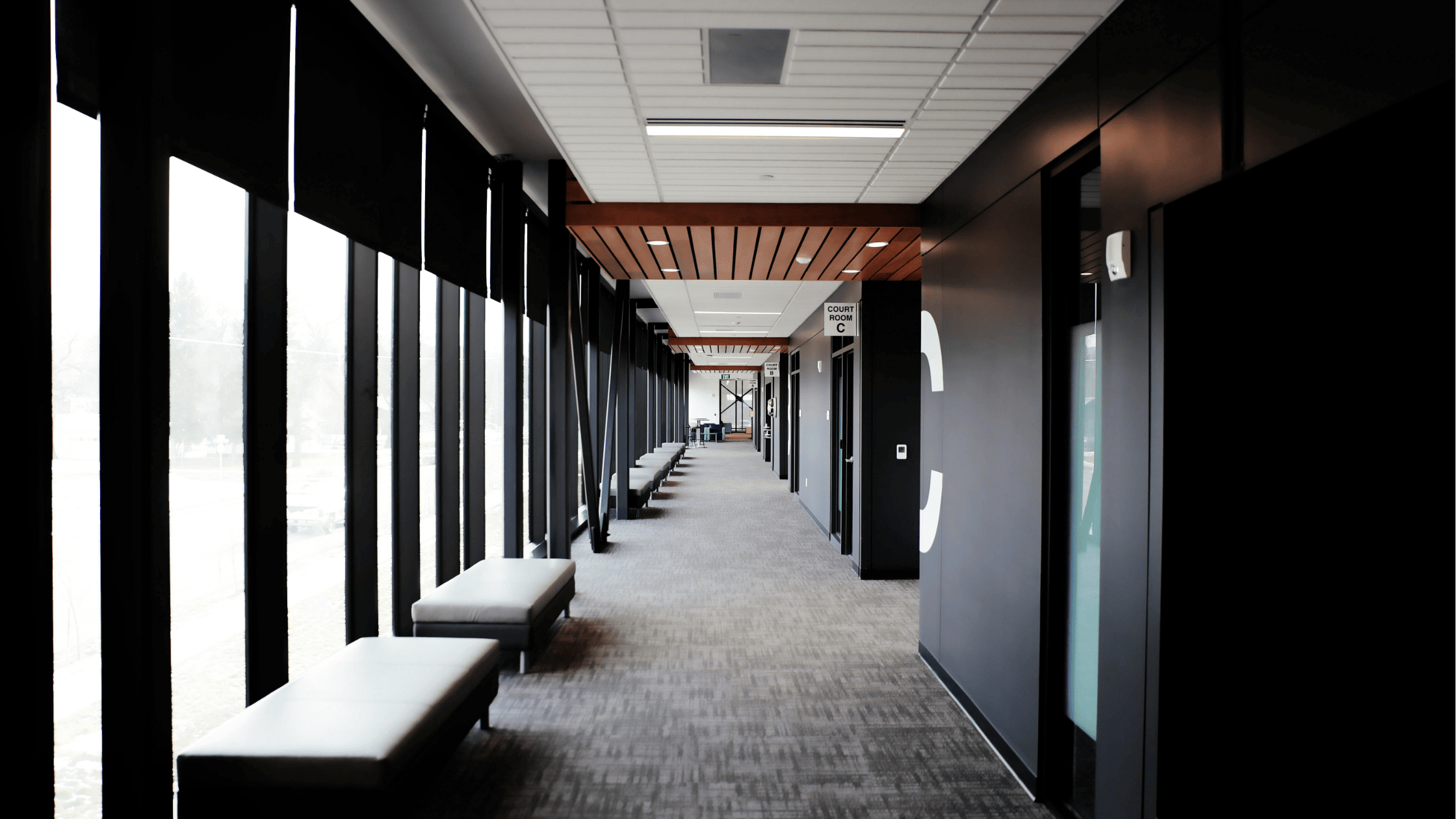 a large office hallway with black walls and windows